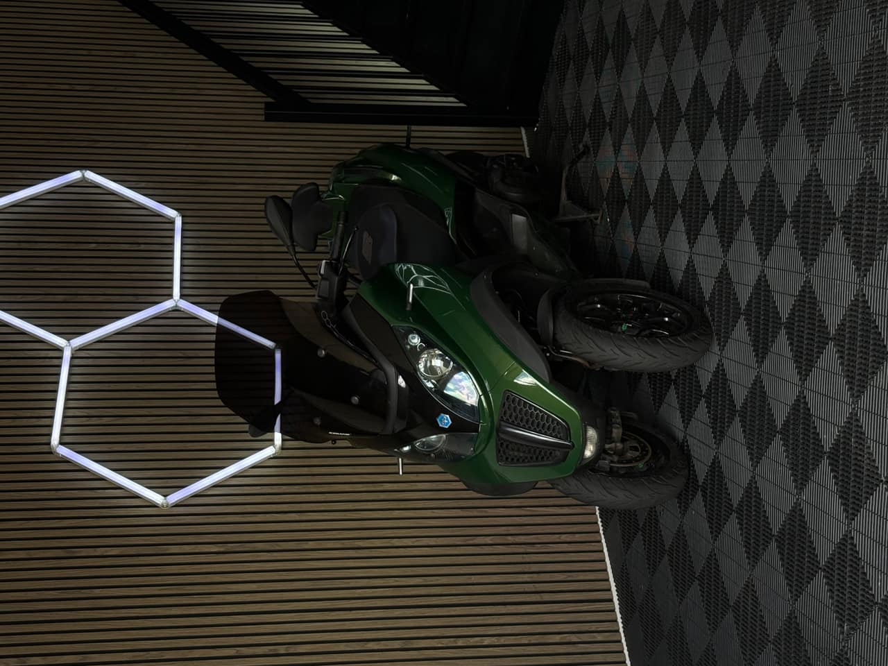 Groene Piaggio MP3 driewieler in de showroom